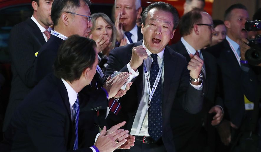 Toshiaki Mikoshiba, center, president and CEO of American Honda Motor Co., reacts after the 2018 Honda Accord won car of the year during the North American International Auto Show, Monday, Jan. 15, 2018, in Detroit. (AP Photo/Carlos Osorio)