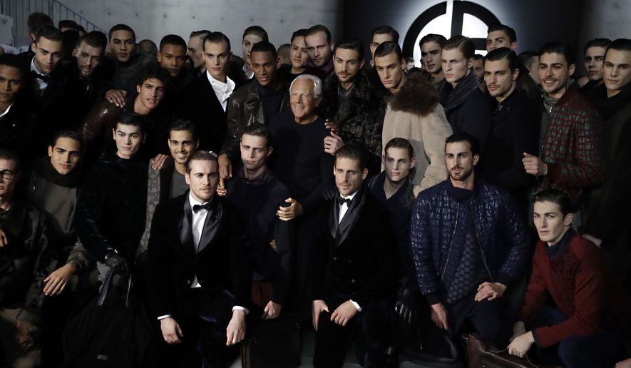Designer Giorgio Armani, centre, poses with models at the end of his men's Fall-Winter 2018-19 collection, that was presented in Milan, Italy, Monday, Jan.15, 2018. (AP Photo/Luca Bruno)