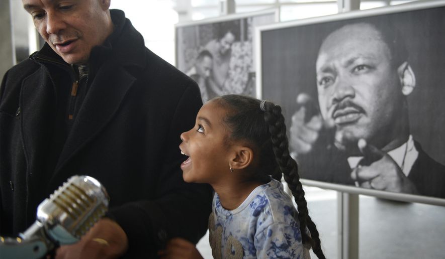 Gabrielle Gressem, 6, celebrates with her father John after she'd read a portion of the Rev. Martin Luther King Jr.'s famous "I Have a Dream" speech at Children's Museum of Pittsburgh on the city's North Side on Monday, Jan. 15, 2018. "He changed America so black people and white people can go to the same places," Gabrielle said of King. The Gressem family lives in Monroeville. (Steve Mellon/Pittsburgh Post-Gazette via AP)