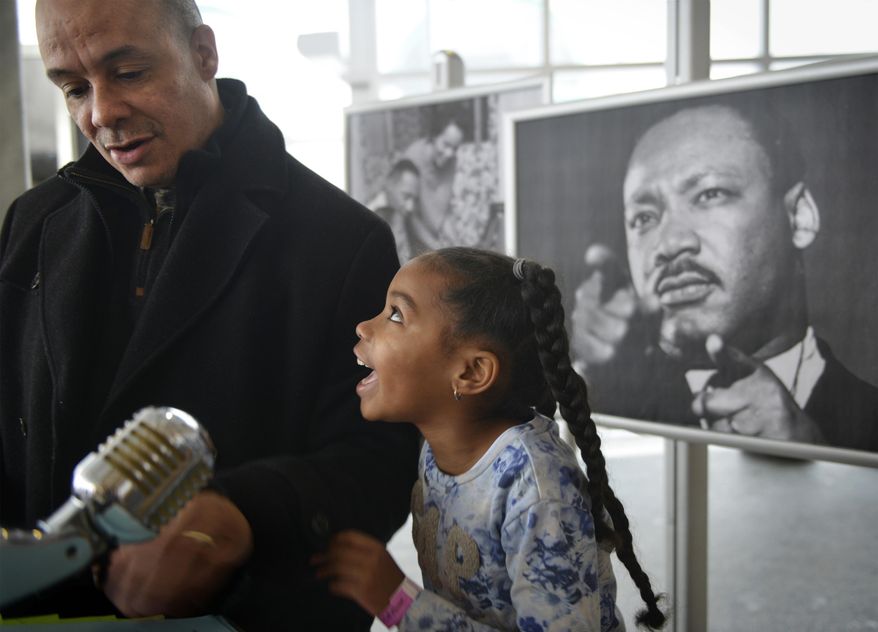 Gabrielle Gressem, 6, celebrates with her father John after she'd read a portion of the Rev. Martin Luther King Jr.'s famous "I Have a Dream" speech at Children's Museum of Pittsburgh on the city's North Side on Monday, Jan. 15, 2018. "He changed America so black people and white people can go to the same places," Gabrielle said of King. The Gressem family lives in Monroeville. (Steve Mellon/Pittsburgh Post-Gazette via AP)