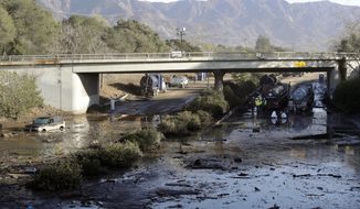 In this Jan. 13, 2018, file photo, crews work on clearing Highway 101 in the aftermath of a mudslide in Montecito, Calif. Officials say the possibility of future catastrophic floods will be in mind as Montecito rebuilds following deadly mudslides that devastated the wealthy coastal hideaway. (AP Photo/Marcio Jose Sanchez, File)