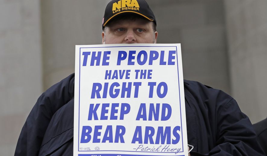 In this Jan. 12, 2018 photo, John Doll, of Renton, Wash., holds a sign that reads &amp;quot;The people have the right to keep and bear arms&amp;quot; during a gun rights rally at the Capitol in Olympia, Wash. A Washington state Legislature Senate committee held a public hearing Monday, Jan. 15, on several bills related to guns, including measures to prohibit high-capacity magazines and to ban so-called bump stocks, trigger modification devices designed to increase the rate of fire of a firearm. (AP Photo/Ted S. Warren)