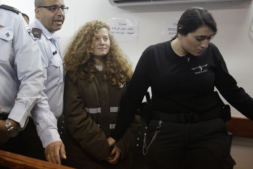 Ahed Tamimi is brought to a courtroom inside the Ofer military prison near Jerusalem, Monday, Jan. 15, 2018. Tamimi, 16, was filmed in December pushing, kicking and slapping Israeli soldiers, who stood by silently. Her father said the girl was upset after her 15-year-old cousin was shot in the head with a rubber bullet.(AP Photo/Sebastian Scheiner)