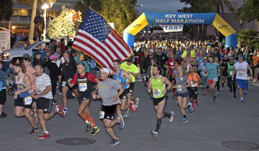 In this photo provided by the Florida Keys News Bureau, participants in the Key West Half Marathon cross the start line Sunday, Jan. 14, 2018, in Key West, Fla. The event attracted runners who competed in two distance categories including the half marathon and 5k divisions. (Rob O'Neal/Florida Keys News Bureau via AP)