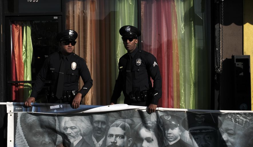Los Angeles police officers hold a banner in commemoration for the 33rd annual Martin Luther King Jr. Day parade in Los Angeles on Monday, Jan. 15, 2018. Thousands of people lined the streets of South Los Angeles for a Martin Luther King Jr. Day parade that is among the nation's biggest celebrations of the holiday. (AP Photo/Richard Vogel)