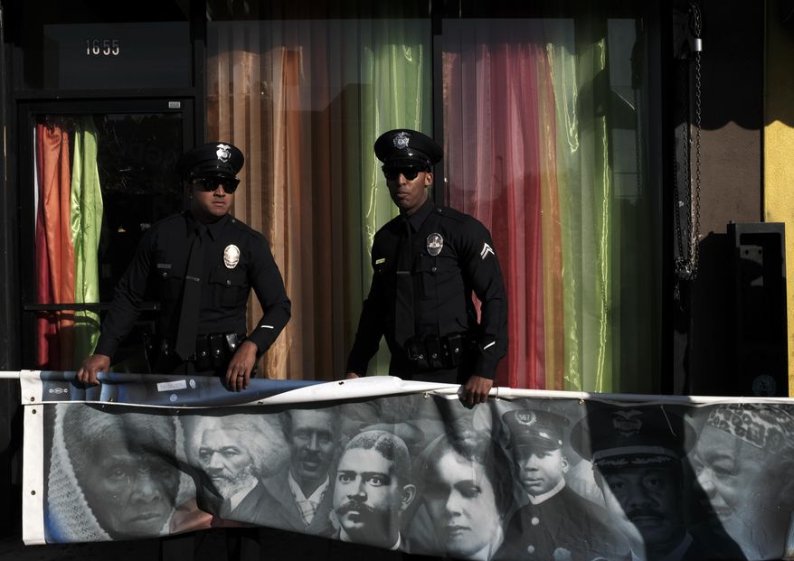 Los Angeles police officers hold a banner in commemoration for the 33rd annual Martin Luther King Jr. Day parade in Los Angeles on Monday, Jan. 15, 2018. Thousands of people lined the streets of South Los Angeles for a Martin Luther King Jr. Day parade that is among the nation's biggest celebrations of the holiday. (AP Photo/Richard Vogel)