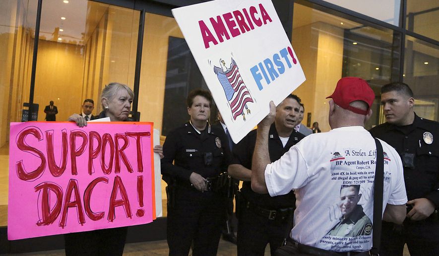 A supporter of President Donald Trump challenges police officers and a Deferred Action for Childhood Arrivals (DACA) program during a rally outside the office of California Democratic Sen. Dianne Feinstein in Los Angeles, Wednesday, Jan. 3, 2018. (AP Photo/Reed Saxon) ** FILE **