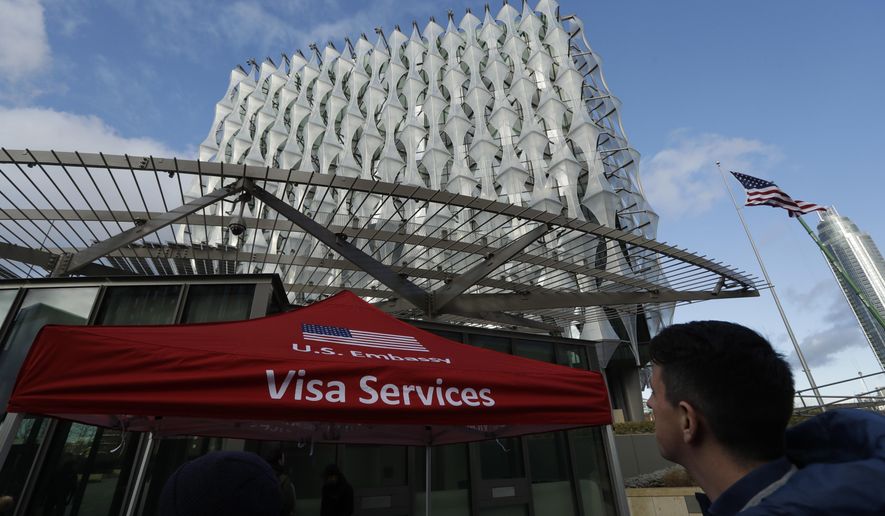 A Visa Services gazebo stands outside as the first group of Visa applicants to go into the new United States Embassy building in London, wait in line outside, Tuesday, Jan. 16, 2018. The new U.S. Embassy in London, denigrated last week by President Donald Trump as too expensive and in a poor location, is set to open to the public. The embassy, in the formerly industrial Nine Elms neighborhood, will open for public business Tuesday. (AP Photo/Matt Dunham)