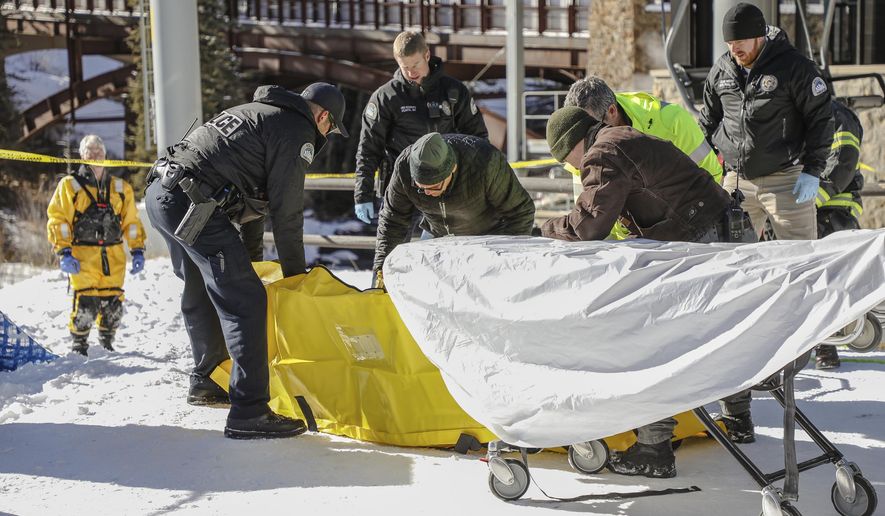 Officials from Vail Fire, Vail Police, Vail Resorts and Eagle County work to remove a body found in Gore Creek under the Lionshead Gondola on Tuesday, Jan. 16, in Vail, Colo. The incident is still being investigated. (Chris Dillmann/Vail Daily via AP)