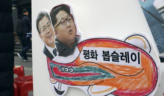 Images of South Korean President Moon Jae-in (left) and North Korean leader Kim Jong-un were on a sign during a rally for a peaceful Winter Olympics in Seoul. North Korea plans to send a spotlight-stealing delegation to next month’s Winter Olympics in the South Korean county of Pyeongchang. The letters read &quot;Peace bobsleigh.&quot; (Associated Press)