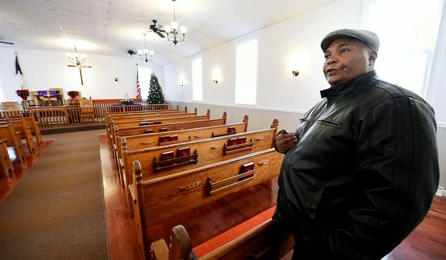 In this undated photo, The Rev. Marlon Carter stands in the newly refurbished Fawn AME Zion Church, in New Park, Pa. Carter said it touches his heart every time he enters the church when he thinks of all the work the congregation endured and the history of an African American church that formed before the Civil War. (Paul Kuehnel/York Daily Record via AP)