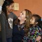 In this Jan. 2, 2018 photo, immigration activist Nora Sandigo, center, talks with Yamilet Salmeron, 11, left, and Britzayda Ramirez, 4, at her home in Miami, FL. At least once a week, Sandigo, a 52-year-old mother of two daughters, drives south to the city of Homestead and drops off donated clothing and food for some of them, mostly people from Mexico and Central America who work on nearby farms. (AP Photo/Lynne Sladky)