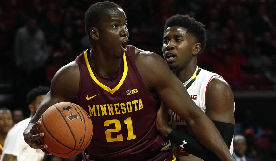 Minnesota center Bakary Konate looks for a teammate as he is pressured by Maryland guard Darryl Morsell, right, during the first half of an NCAA college basketball game in College Park, Md., Thursday, Jan. 18, 2018. (AP Photo/Patrick Semansky)