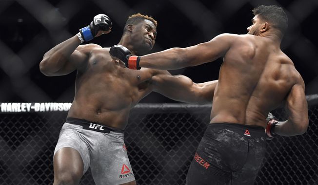 FILE- In this Dec. 2, 2017, file photo, Francis Ngannou, left, hits Alistair Overeem in the first round during a UFC 218 heavyweight mixed martial arts bout, in Detroit. Ngannou defeated Overeem by first-round knockout. Ngannou has knockout power that snaps heads back like Pez dispensers and earned him comparisons to Mike Tyson in his ferocious heyday. Ngannou will compete in the heavyweight champion bout against Stipe Miocic in the main event of UFC 220. (AP Photo/Jose Juarez, File)