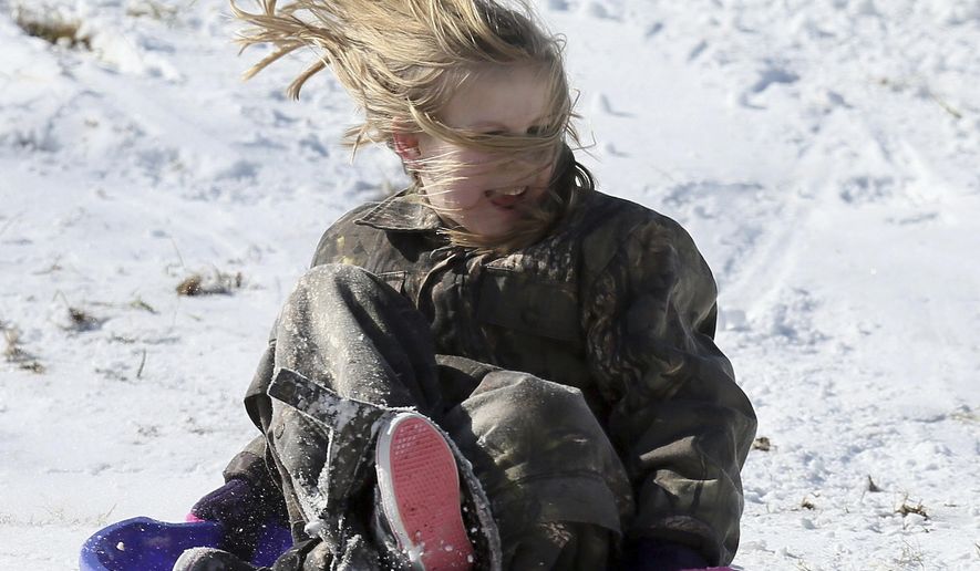 Blythe Kiser, 8, enjoys a ride on a saucer sled Thursday, Jan. 18, 2018,  at Nash Community College in Rocky Mount, N.C.  (Alan Campbell/The Rocky Mount Telegram via AP)