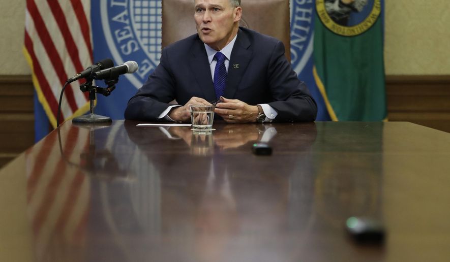 Washington Gov. Jay Inslee takes questions from reporters after he signed the capital budget, Friday, Jan. 19, 2018 at the Capitol in Olympia, Wash. The signing came after the state Legislature approved more than $4 billion in construction projects across the state after reaching a deal on a contentious water issue that had stalled the capital budget for months. (AP Photo/Ted S. Warren)