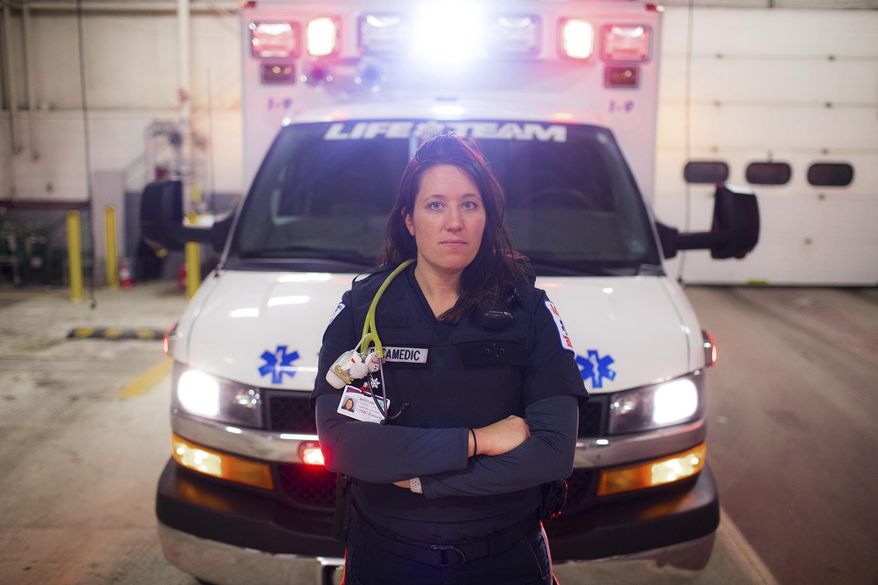 In this Thursday, Jan. 11, 2018 photo, paramedic Brittani Bissell poses wearing a bulletproof vest in Harrisburg, Pa. calls and the mass shooting in Las Vegas last year. The threat of increasing assaults as EMTs respond to calls to aid the sick and injured has prompted more and more ambulance units in central Pennsylvania to equip them with body armor. (Sean Simmers/PennLive.com via AP)