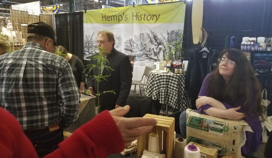 In this Tuesday, Jan. 9, 2018 photo, Erica McBride, executive director of both the Pennsylvania Hemp Industry Council and the National Hemp Association, listens as a Pennsylvania Farm Show attendee asks a question at the hemp exhibit at the Pennsylvania Farm Show Complex & Expo Center in Harrisburg, Pa. (Tom Knapp/LNP via AP)