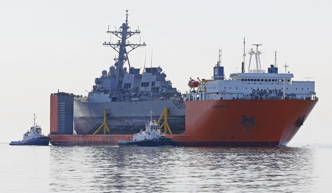 The transport vessel Transshelf carries the damaged USS Fitzgerald, a U.S. Navy destroyer, towards the Pascagoula River in Pascagoula, Miss., Friday, Jan. 19, 2018. The ship was damaged in a June collision off Japan, that killed seven sailors. (AP Photo/Rogelio V. Solis)
