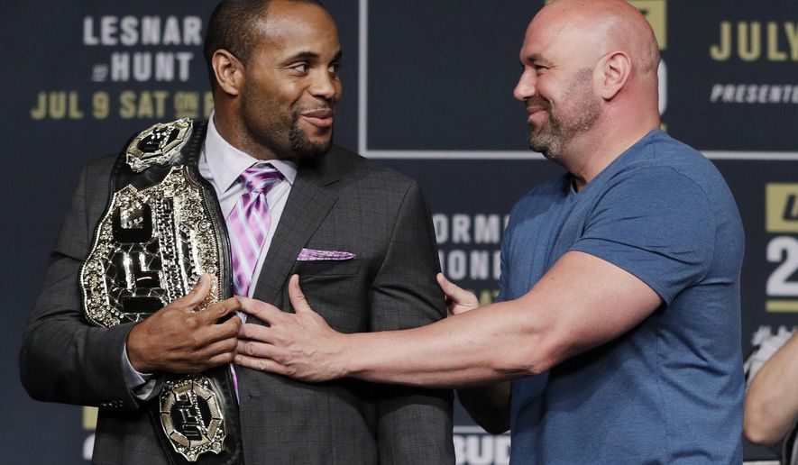 FILE - In this July 6, 2016, file photo, Dana White, right, President of the Ultimate Fighting Championship, holds back Daniel Cormier during a UFC 200 mixed martial arts news conference in Las Vegas. Cormier is pumped to defend his UFC light heavyweight championship and says he can beat Volkan Oezdemir. They will fight at UFC 220 on Jan. 20, 2018, in Boston. (AP Photo/John Locher, File)