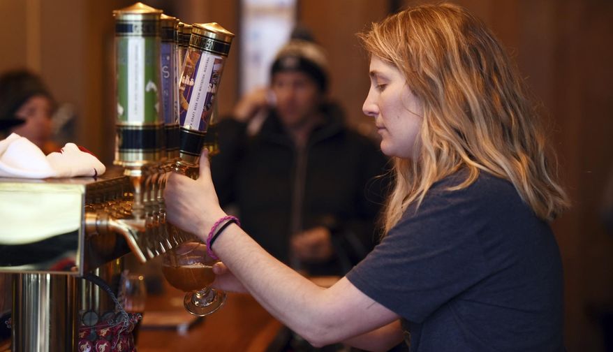 In this Jan. 4, 2018, photo, Erin Krueger pours a pitcher of their Ski Socks American Sour at the Great Northern Brewing Company in Whitefish, Mont. (Brenda Ahearn/The Daily Inter Lake via AP)