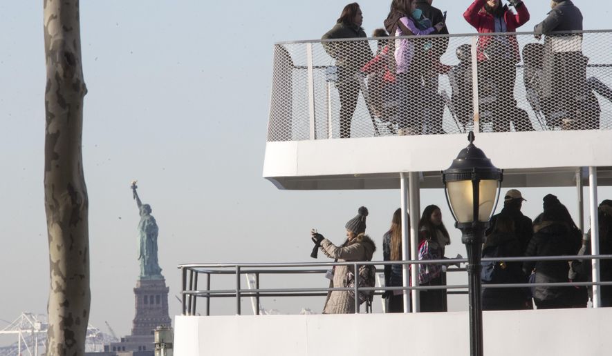 Visitors to the Statue of Liberty take photos from onboard a ferry that will cruise the bay around the statue and Ellis Island, Saturday, Jan. 20, 2018, in New York. The National Park Service announced that the Statue of Liberty and Ellis Island would be closed Saturday &amp;quot;due to a lapse in appropriations.&amp;quot; Late Friday, the Senate failed to approve legislation to keep the government from shutting down after the midnight deadline. (AP Photo/Mary Altaffer)
