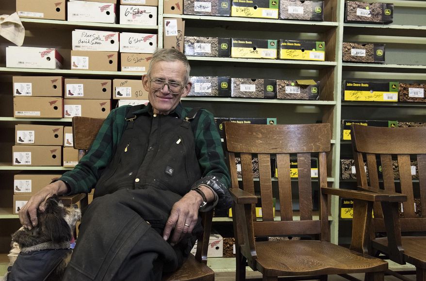 ADVANCE FOR USE SATURDAY, JAN. 20 - In this Jan. 12, 2018 photo, George Marburger, owner of Marburger's For Shoes on East Square, poses in the store with his dog Nevaeh in Humboldt, Neb. Marburger recently became owner of the weekly newspaper The Humboldt Standard. (Gwyneth Roberts/The Journal-Star via AP)