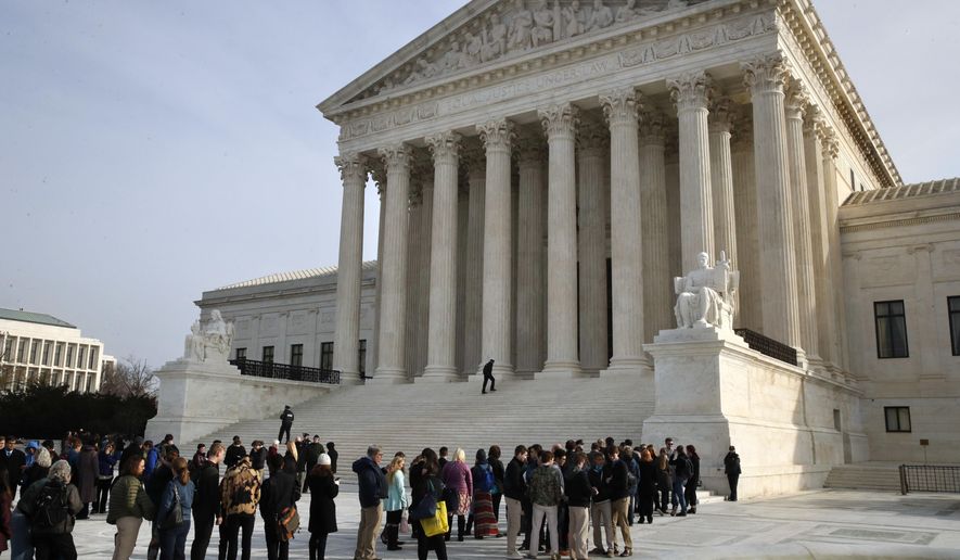 In this Dec. 4, 2017 photo, people stand in line to enter the Supreme Court in Washington. The Supreme Court is agreeing to decide the legality of the latest version of President Donald Trump’s ban on travel to the United States by residents of six mostly Muslim countries The justices plan to hear argument in April and issue a final ruling by late June. The action follows last month’s ruling by the federal appeals court in San Francisco that struck down the travel ban. (AP Photo/Jacquelyn Martin)