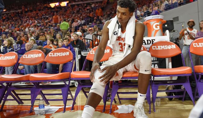 Clemson's Donte Grantham holds his knee after an injury during the second half of an NCAA college basketball game against Notre Dame Saturday, Jan. 20, 2018, in Clemson, S.C. Clemson won 67-58. (AP Photo/Richard Shiro)