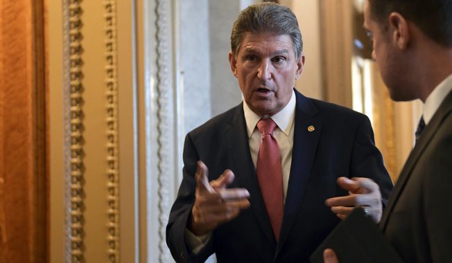 Sen. Joe Manchin, D-W.Va., talks with a staffer on Capitol Hill in Washington, Monday, Jan. 22, 2018, after passage of a procedural vote aimed at reopening the government. (AP Photo/Susan Walsh)