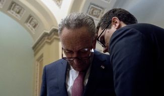 Senate Minority Leader Sen. Chuck Schumer of N.Y., left, speaks to an aide following a Senate policy luncheon on Capitol Hill in Washington, Tuesday, Jan. 23, 2018. (AP Photo/Andrew Harnik)
