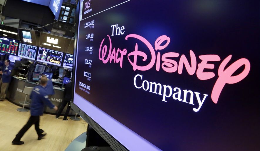 FILE - In this Monday, Aug. 7, 2017, file photo, The Walt Disney Co. logo appears on a screen above the floor of the New York Stock Exchange. The Walt Disney Co. announced Tuesday, Jan. 23, 2018, that it will give more than 125,000 eligible employees a one-time $1,000 cash bonus and invest $50 million in an education funding program. (AP Photo/Richard Drew, File)