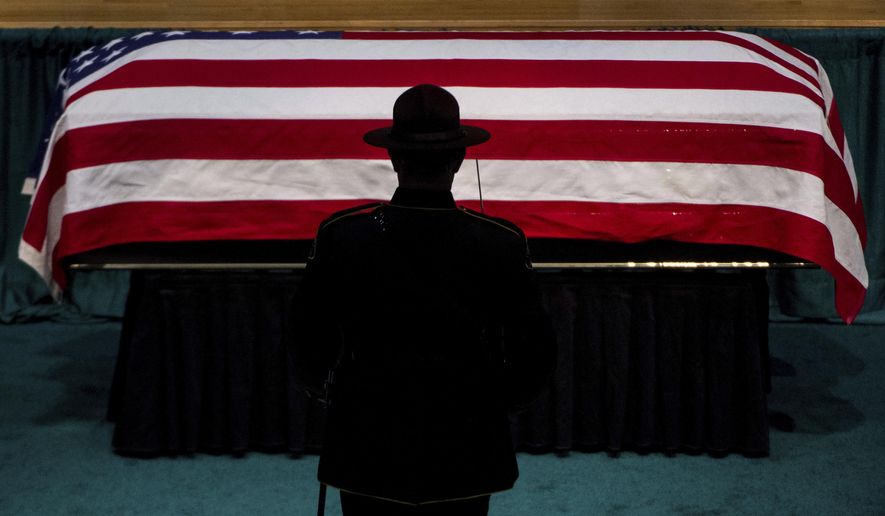 A member of the honor guard approaches the casket, Wednesday, Jan. 17, 2018, during a memorial service for Pierce County Sheriff's Deputy Daniel McCartney, at Pacific Lutheran University in Tacoma, Wash. McCartney died on Sunday, Jan. 7, after being shot while responding to a break-in call southeast of Tacoma. (Joshua Bessex /The News Tribune via AP, Pool)
