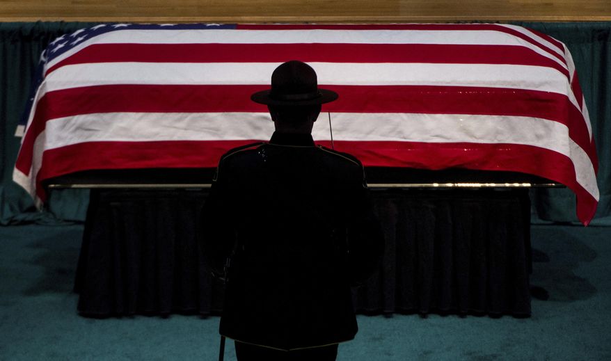 A member of the honor guard approaches the casket, Wednesday, Jan. 17, 2018, during a memorial service for Pierce County Sheriff's Deputy Daniel McCartney, at Pacific Lutheran University in Tacoma, Wash. McCartney died on Sunday, Jan. 7, after being shot while responding to a break-in call southeast of Tacoma. (Joshua Bessex /The News Tribune via AP, Pool)