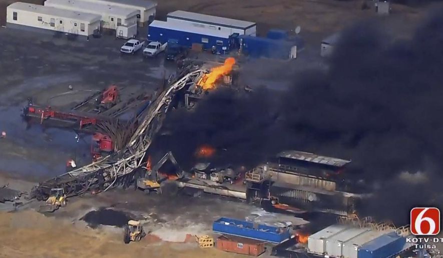 In this photo provided from a frame grab from Tulsa's KOTV/NewsOn6.com, fires burn at an eastern Oklahoma drilling rig near Quinton, Okla., Monday Jan. 22, 2018. Five people are missing after a fiery explosion ripped through a drilling rig, sending plumes of black smoke into the air and leaving a derrick crumpled on the ground, emergency officials said. (Christina Goodvoice, KOTV/NewsOn6.com via AP)