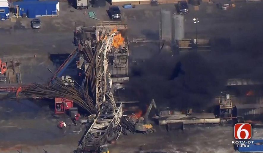 In this photo provided from a frame grab from Tulsa's KOTV/NewsOn6.com, fires burn at an eastern Oklahoma drilling rig near Quinton, Okla., Monday Jan. 22, 2018. Five people are missing after a fiery explosion ripped through a drilling rig, sending plumes of black smoke into the air and leaving a derrick crumpled on the ground, emergency officials said. (Christina Goodvoice, KOTV/NewsOn6.com via AP)