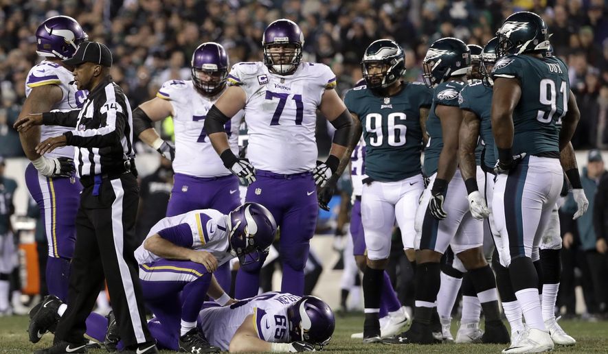 Minnesota Vikings' Case Keenum (7) checks on an injured Pat Elflein (65) during the second half of the NFL football NFC championship game against the Philadelphia Eagles Sunday, Jan. 21, 2018, in Philadelphia. (AP Photo/Matt Slocum)