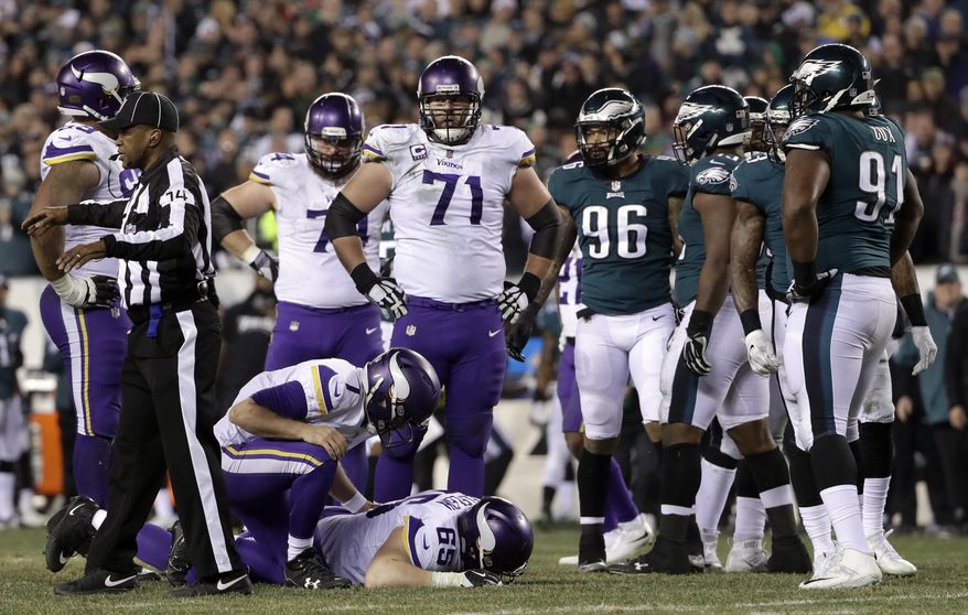 Minnesota Vikings' Case Keenum (7) checks on an injured Pat Elflein (65) during the second half of the NFL football NFC championship game against the Philadelphia Eagles Sunday, Jan. 21, 2018, in Philadelphia. (AP Photo/Matt Slocum)