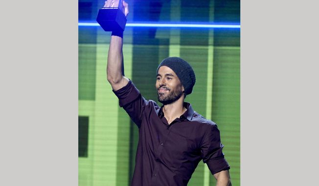 FILE - In this Oct. 26, 2017 file photo, Enrique Iglesias accepts the artist of the year award at the Latin American Music Awards in Los Angeles. Iglesias is suing Universal Music Group in a dispute over how much he is paid for songs played on streaming music services. (Photo by Chris Pizzello/Invision/AP, File)