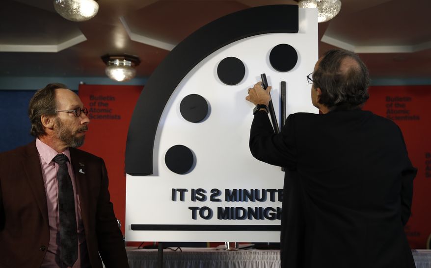 Robert Rosner, chairman of the Bulletin of the Atomic Scientists, right, joined by Bulletin of the Atomic Scientists member Lawrence Krauss, left, moves the minute hand of the Doomsday Clock to two minutes to midnight during a news conference at the National Press Club in Washington, Thursday, Jan. 25, 2018. ( AP Photo/Carolyn Kaster)