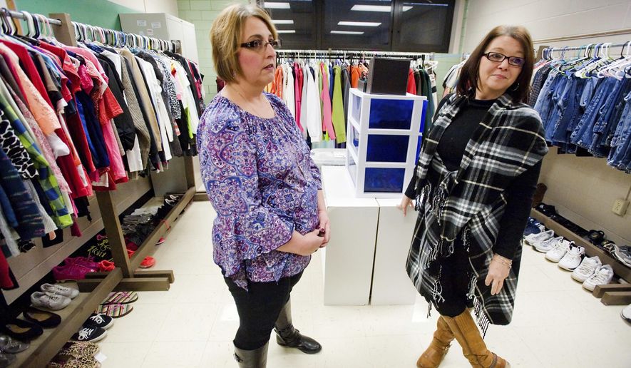 In this Jan. 4, 2018 photo, special education teacher Angel Warman, left, and Loretta Phillips, right, para-professional, talk about the clothing room at Charleston High School in Charleston, Ill. Two years ago, Warman realized some students weren't going to prom or other school dances because they didn't have the right attire. She began collecting formal wear, told other teachers about the effort and it "evolved" into more. The reaction was such that it went from having a small room for prom dresses and the like to CHS Principal Trevor Doughty allowing the use of an unused classroom for the clothing pantry. (Kevin Kilhoffer/Journal Gazette via AP)