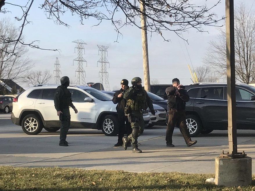 Authorities respond to reports of a robbery at Citizens Bank in Canton Township, Mich., Thursday, Jan. 25, 2018. Police in suburban Detroit say they're negotiating with a man holding hostages inside the Citizens Bank branch following a failed robbery. (Kaylee McGhee/Detroit News via AP)