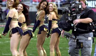 FILE - In this Feb. 17, 2001, file photo,a  television cameraman photographs the Los Angeles Xtreme cheerleaders before the start of an XFL football game between the Xtreme and the Las Vegas Outlaws in Las Vegas. The XFL is set for a surprising second life, WWE leader Vince McMahon announced Thursday, Jan. 25, 2018. McMahon said the XFL would return in 2020 but offered few other details about the late winter/early spring football league. (AP Photo/Jeff Klein, File)