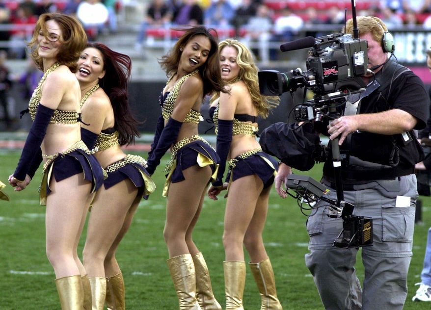 FILE - In this Feb. 17, 2001, file photo,a television cameraman photographs the Los Angeles Xtreme cheerleaders before the start of an XFL football game between the Xtreme and the Las Vegas Outlaws in Las Vegas. The XFL is set for a surprising second life, WWE leader Vince McMahon announced Thursday, Jan. 25, 2018. McMahon said the XFL would return in 2020 but offered few other details about the late winter/early spring football league. (AP Photo/Jeff Klein, File)