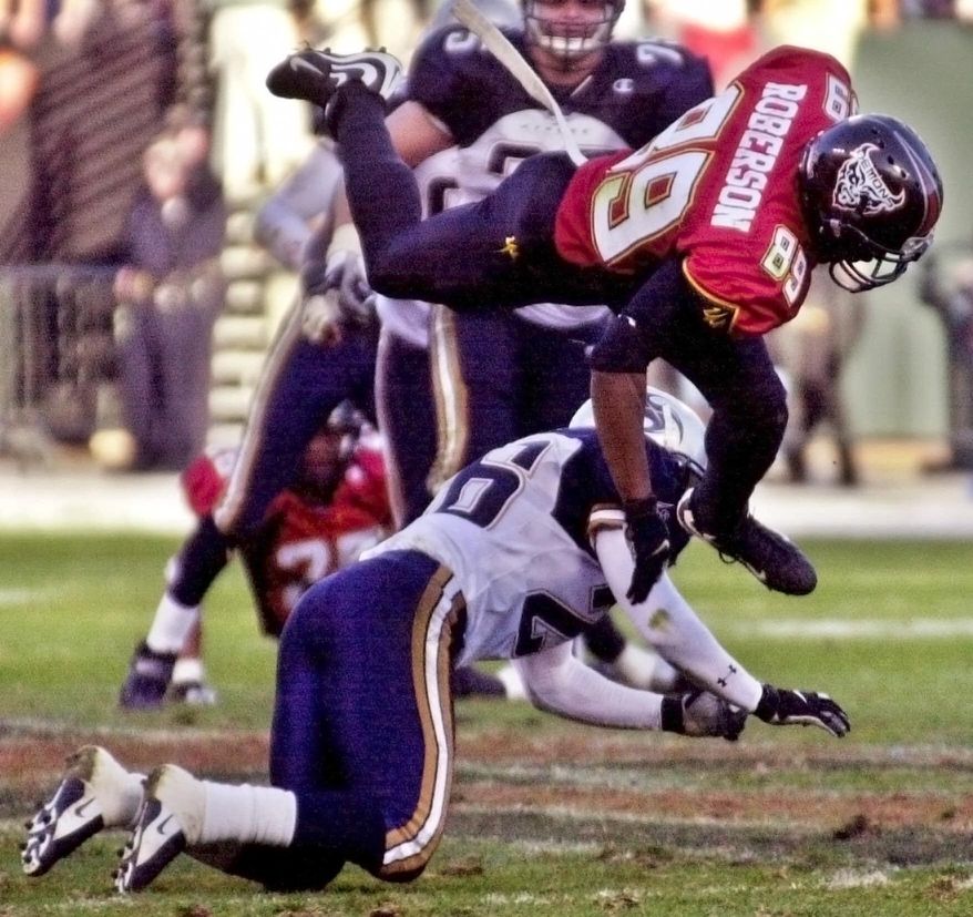 FILE - In this Feb. 4, 2001, file photo, San Francisco Demons wide receiver Brian Roberson jumps over Los Angeles Xtreme cornerback Dell McGee duringthe fourth quarter of an XFL football fam in San Francisco. The XFL is set for a surprising second life, WWE leader Vince McMahon announced Thursday, Jan. 25, 2018. McMahon said the XFL would return in 2020 but offered few other details about the late winter/early spring football league. (AP Photo/Paul Sakuma, FIle)