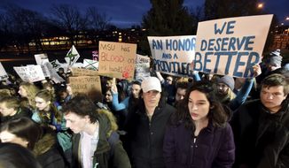 Demonstrators gather at &quot;The Rock&quot; on Michigan State University&#39;s East Lansing, Mich., campus to support victims of disgraced former sports doctor Larry Nassar and call for more changes in leadership at the university. (Dale G. Young/Detroit News via AP)