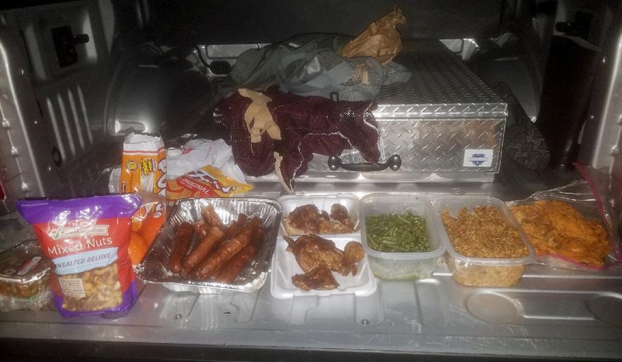 This Wednesday, Jan, 24, 2018, photo provided by the Jefferson County Sheriff's Office in Beaumont, Texas, shows home-cooked treats taken from federal inmate Joshua Hansen, after he escaped from a federal prison near Beaumont with the intention of breaking back in laden with a duffle bag with bottles of alcohol and home-cooked treats. He was arrested Jan. 24, as he ran onto private land near the prison. (Jefferson County Sheriff's Office via AP)