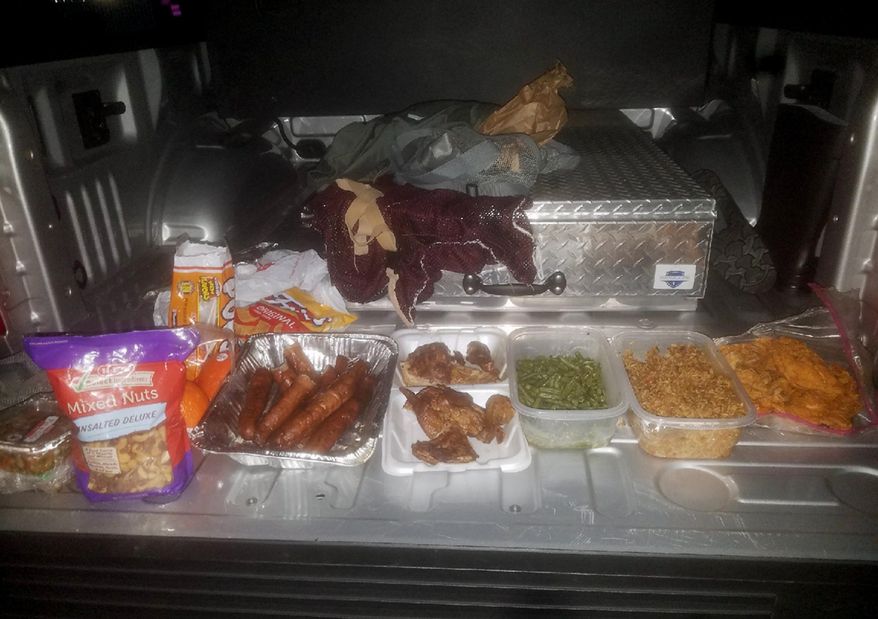 This Wednesday, Jan, 24, 2018, photo provided by the Jefferson County Sheriff's Office in Beaumont, Texas, shows home-cooked treats taken from federal inmate Joshua Hansen, after he escaped from a federal prison near Beaumont with the intention of breaking back in laden with a duffle bag with bottles of alcohol and home-cooked treats. He was arrested Jan. 24, as he ran onto private land near the prison. (Jefferson County Sheriff's Office via AP)