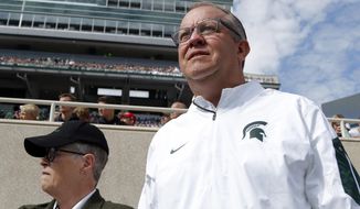 FILE - In this Sept. 24, 2016, file photo, Michigan State University athletics director Mark Hollis, right, and president Lou Anna Simon watch the action during an NCAA college football game against Wisconsin, in East Lansing, Mich. Hollis has built a reputation on the foundation of innovation at Michigan State, putting hockey and basketball games in football stadiums. His legacy, though, may be marred by Larry Nassar. A day after Michigan State President Lou Anna Simon resigned amid an outcry over the school&#39;s handling of allegations against the disgraced doctor, Hollis’ future as its athletic director may be tenuous. (AP Photo/Al Goldis, File)