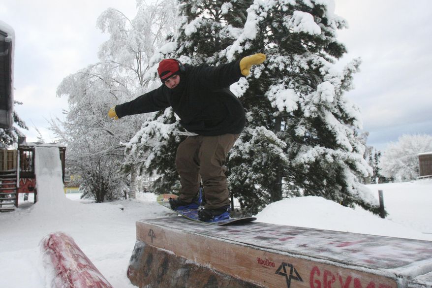 In a Monday Jan. 15, 2018 photo, Josh Martinez snowboards over a box in his backyard terrain park in Fairbanks, Alaska. Martinez has been snowboarding since he was a teenager and previously managed the Hulbert Nanook Terrain Park at the University of Alaska Fairbanks. (Sam Friedman/Fairbanks Daily News-Miner via AP)
